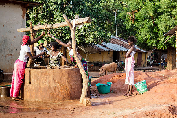Ziguinchor,Senegal - July 2, 2012:Group of young African women extracting water of a well to use domestic, in Ziguinchor's village, Senegal